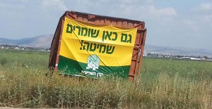 The sign reads: “Here we also keep the Sabbath of the Land” Mount Gilboa is in the background. Photo: Miriam Feinberg Vamosh 